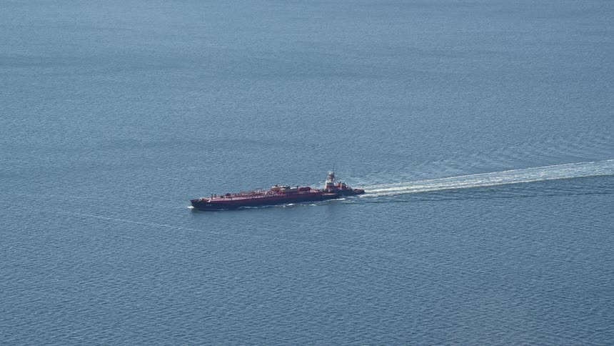 Freighter cruises through water leaving large wake