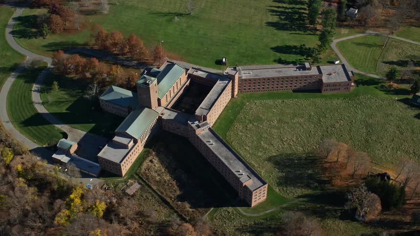 An aerial view of a brown structure close to the woods