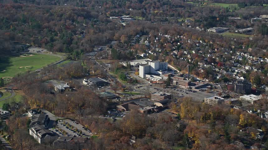 A sub urban town with residential buildings surrounded by trees