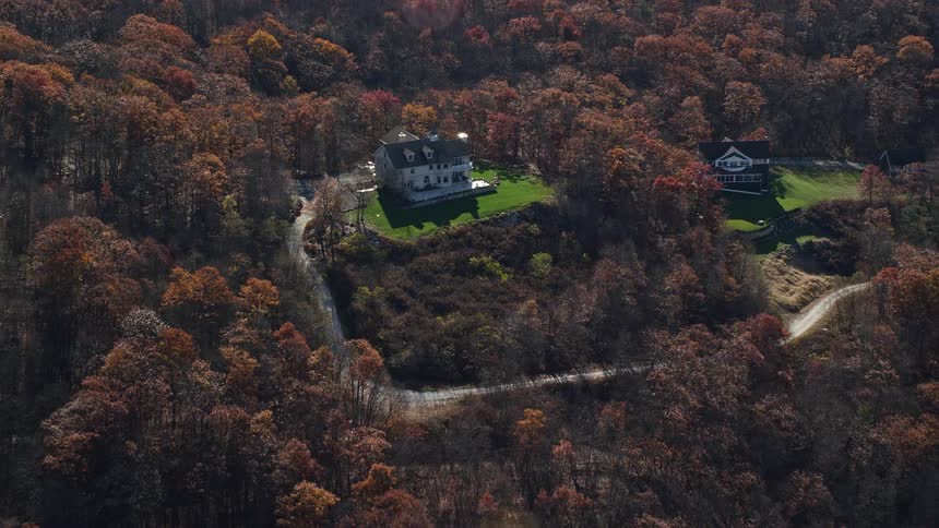 An aerial view of two lone buildings in the wood forest