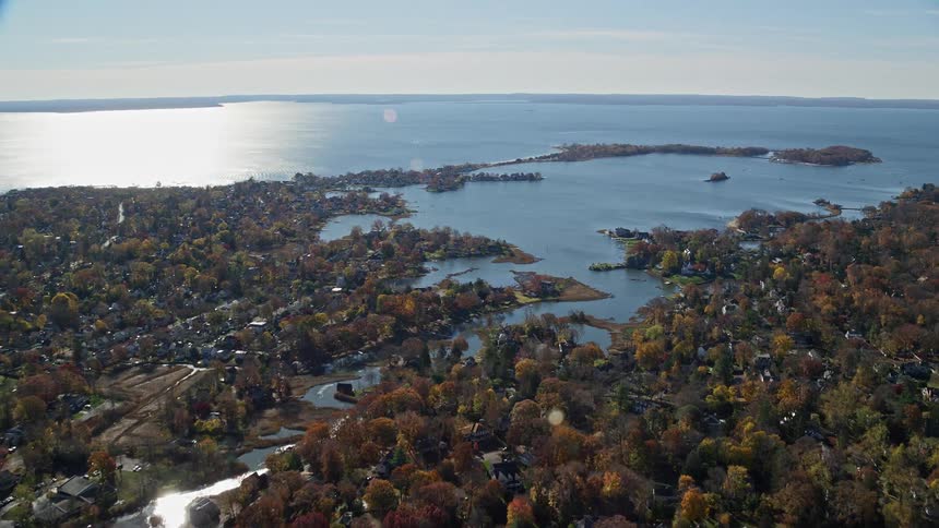 An aerial view of a wood land rural community close to the sea shore