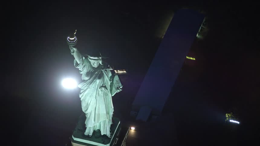 Aerial of the statue of liberty illuminated at night