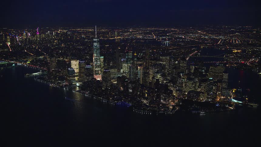 Buildings at waterfront in new york city metropolitan area at night