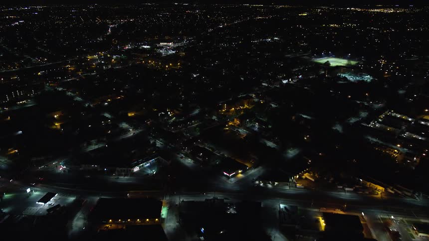 The city at night is looking dark with lots of structures roads having faint lights