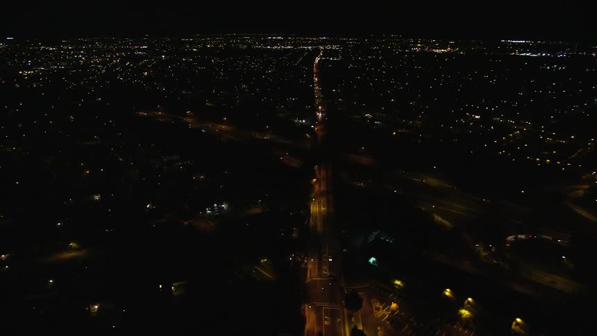 Aerial panorama of a highway at night amidst an urban city