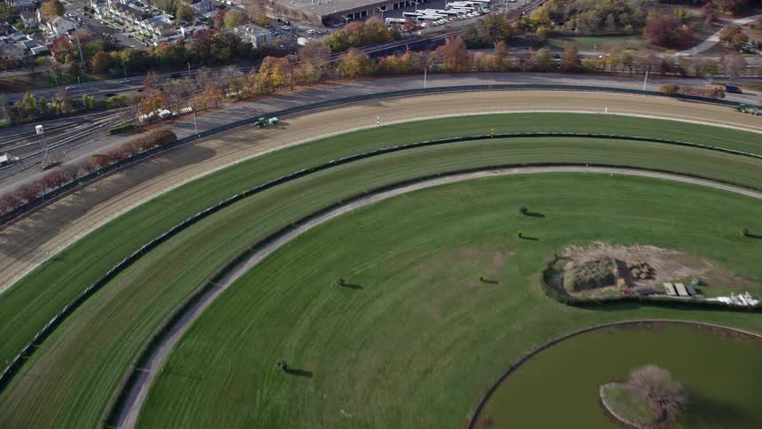 Aerial view of a park with a pond next to a mall