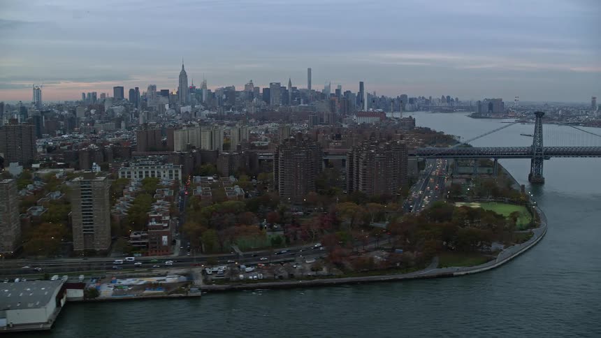 An aerial view of a shoreline bridge baseball field in a metropolis