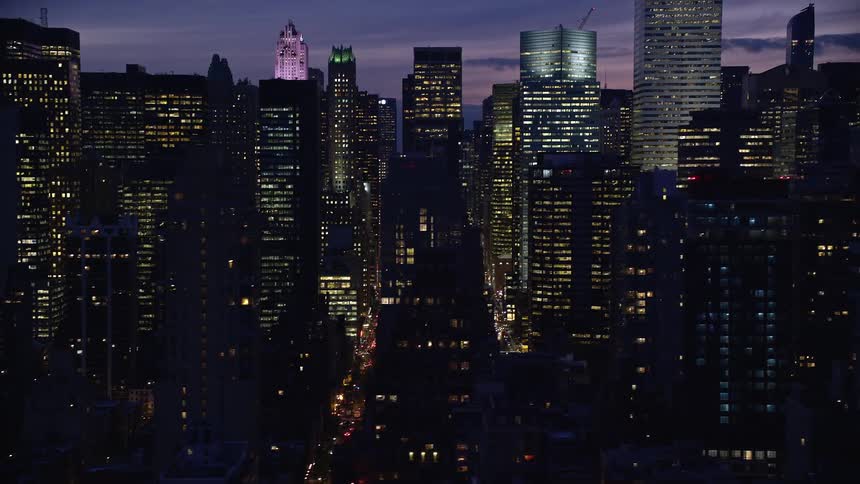 Aerial of the city with illuminated glass towers at dusk