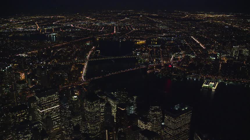 Aerial of bridges and skyscrapers in a city at night