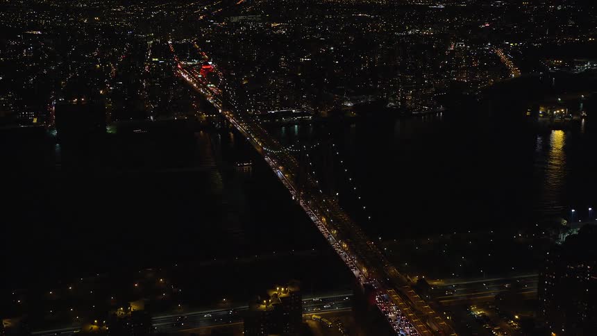 Aerial view of a metropolitan city with a bridge spanning the sea amidst cities