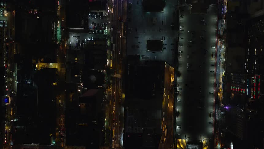 Aerial of buildings and moving cars in a city at night