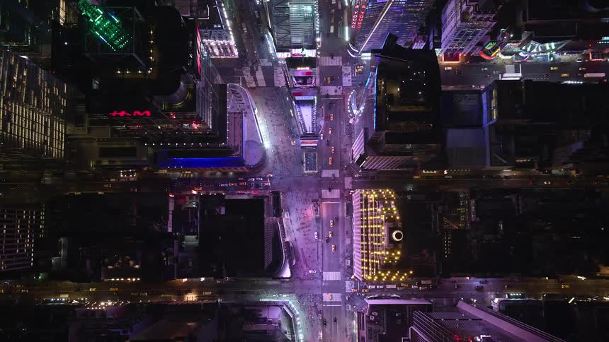 Aerial of skyscrapers and moving cars in a metropolitan area at night