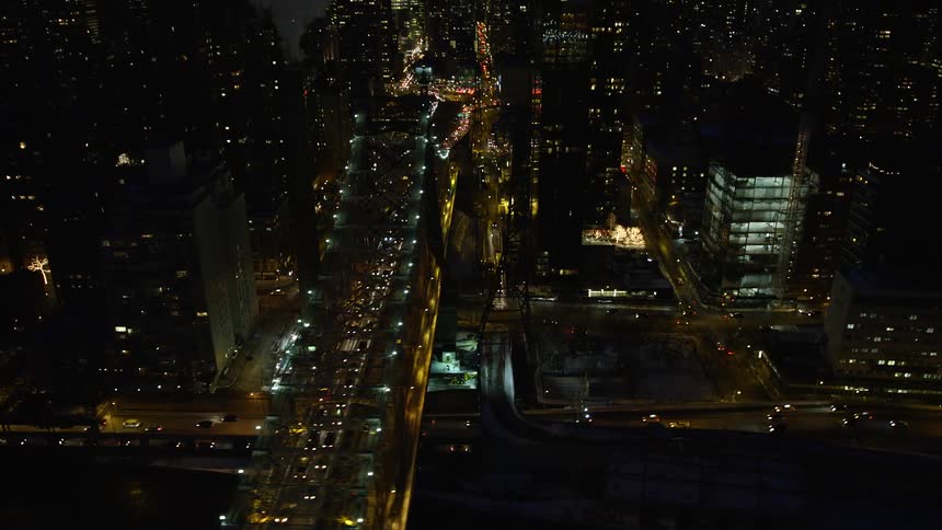 Aerial of a large city with a bridge with heavy traffic at night