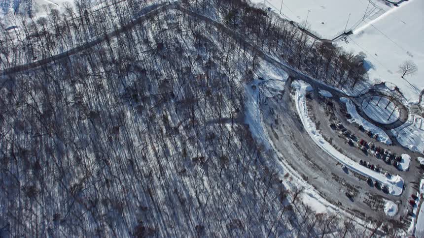 An aerial view of a snowy region with roads and houses