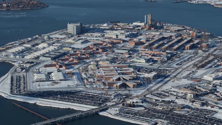 Aerial view of a city with factories and complexes in the middle of an island surrounded by the sea