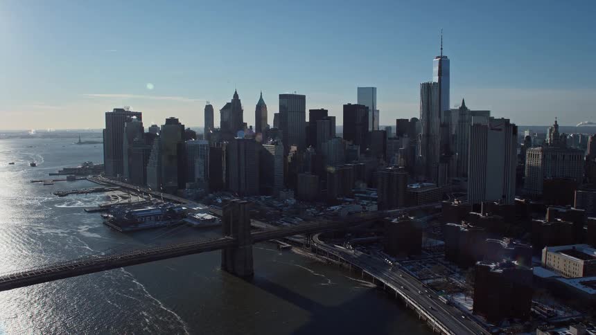 Aerial view of a metropolis by the sea with bridges and the sun shining during the day