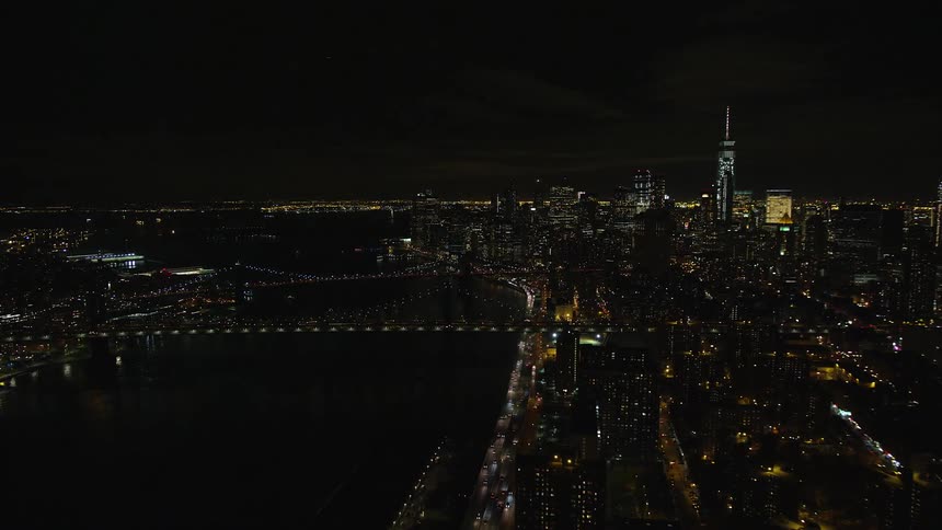Aerial panorama of a nighttime metropolitan city by the seaside