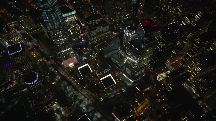 Skyline of a city with glass towers illuminated at night
