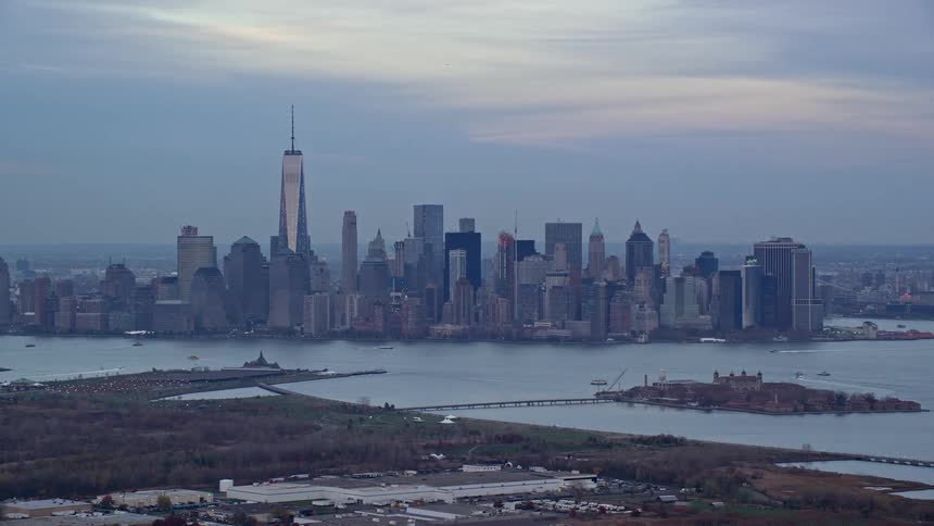 A city with high rise building surrounded by a river with a small island in the middle having linking bridge from land to the island