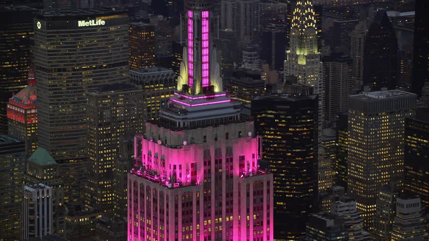 Aerial panorama of a skyscraper with pink lighting in the midst of a metropolis