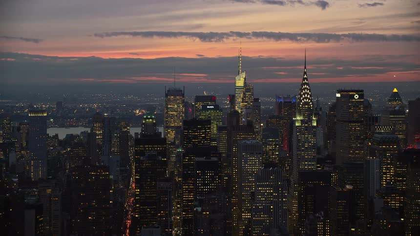 Aerial view of a metropolis in an evening sky with skyscrapers along the coastline