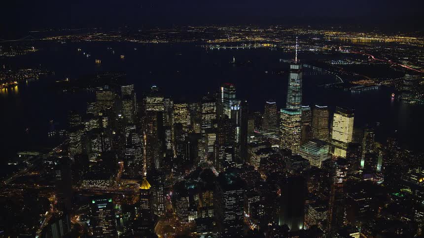 Nighttime aerial panorama of a metropolis with skyscrapers by the seaside