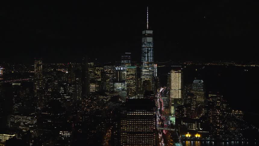 Aerial view of a metropolis at night with skyscrapers by the seaside
