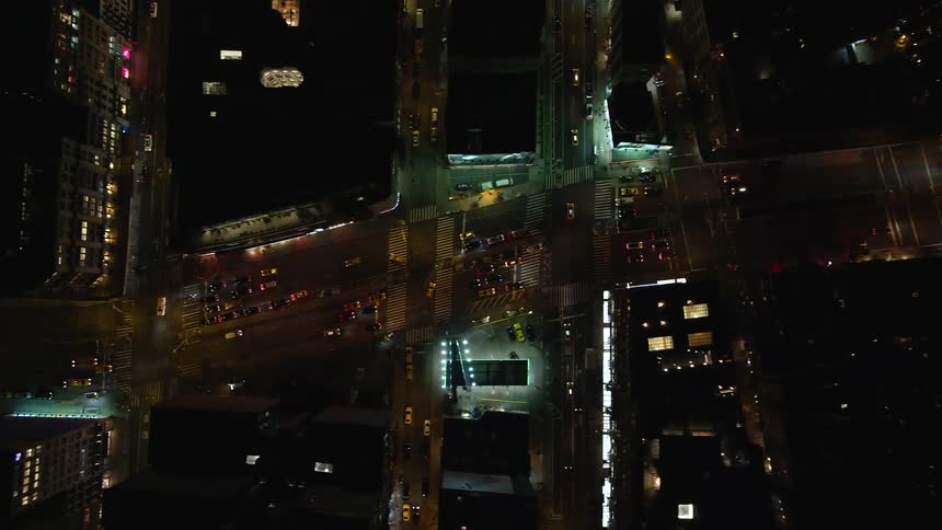 Aerial view of a metropolis with a perspective of intersections and streets in a nighttime cityscape