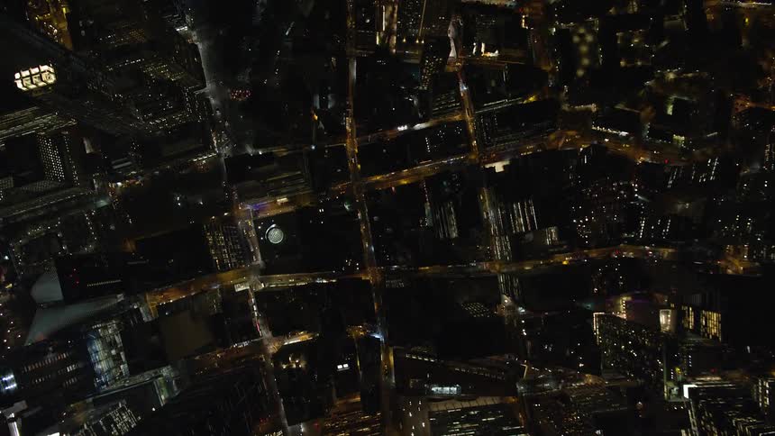 Aerial view of a nighttime metropolitan city with streets and traffic
