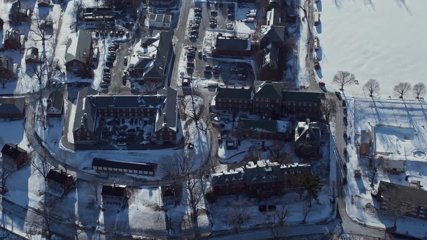 Aerial of snow covered housing and nearby field