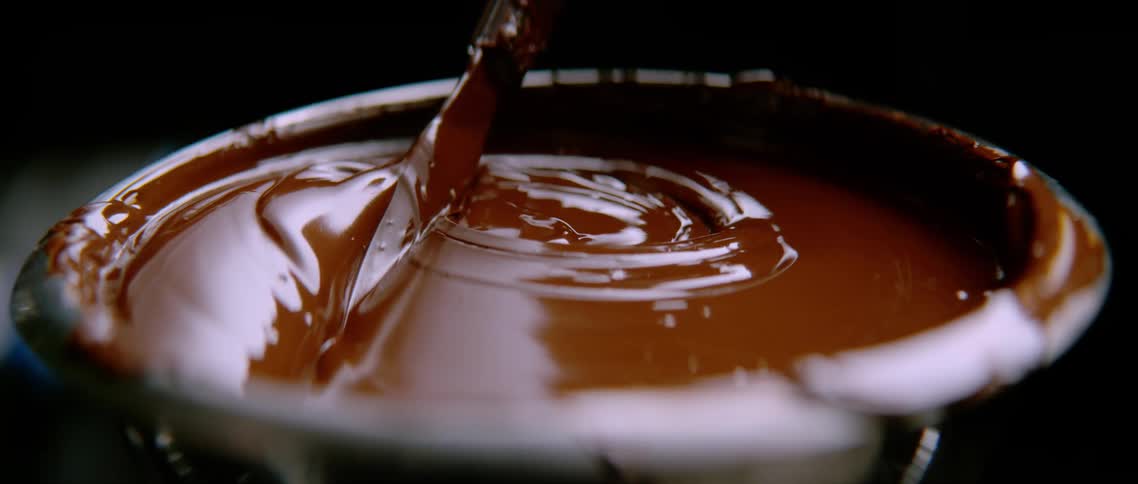A person is mixing a bowl of chocolate