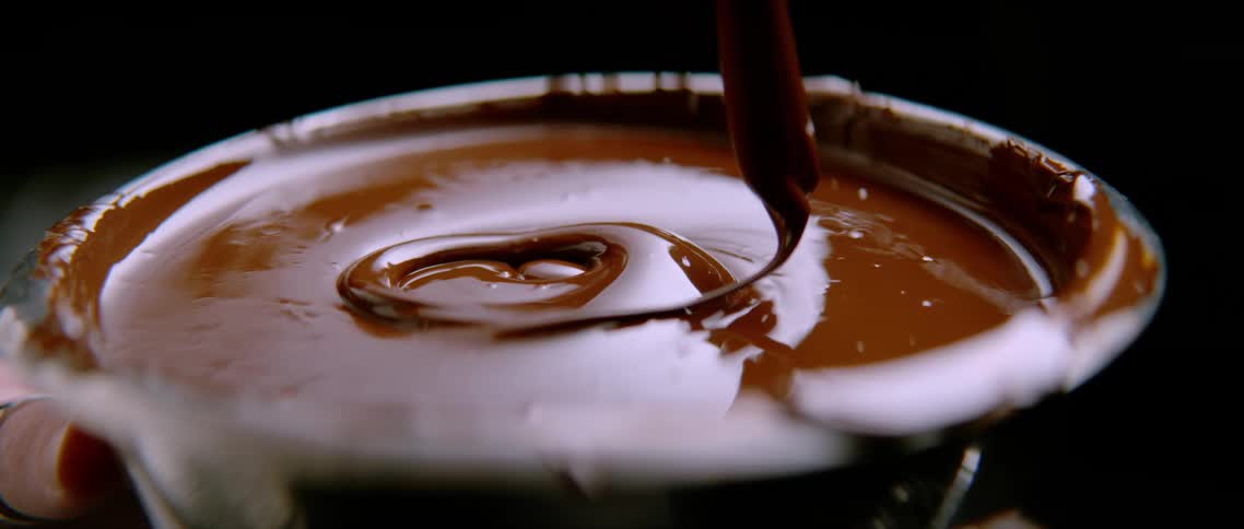 Dense chocolate syrup being poured into a container