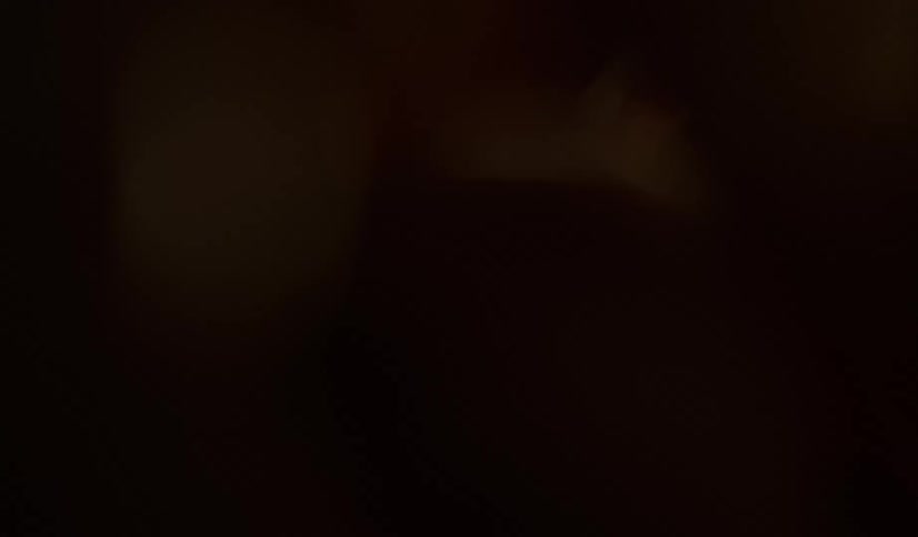 Almonds and chocolate flow upward through dark area partially lit by light
