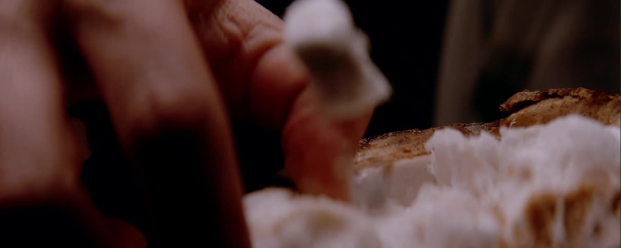 Extreme closeup of a persons fingers taking a flake from a coconut