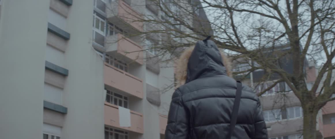 A man is walking towards the apartment buildings