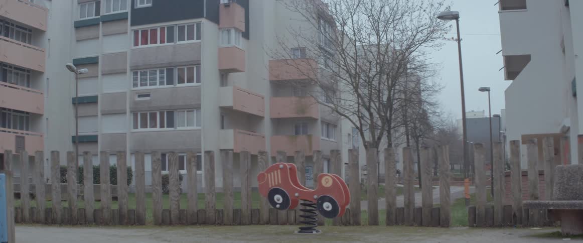 A spring rider car at a playground bounces back and forth