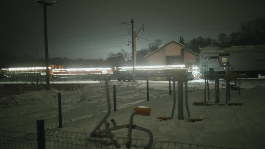 A train travels over the bridge at night