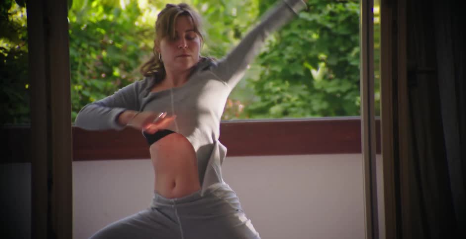 A lady doing stretches on the balcony during the day