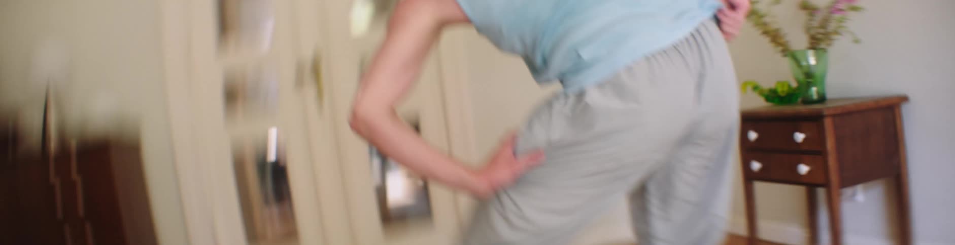 A young man dances indoors with a huge smile on his face as the camera moves erratically