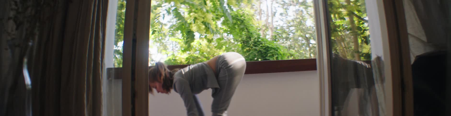 Woman moves through yoga poses on balcony