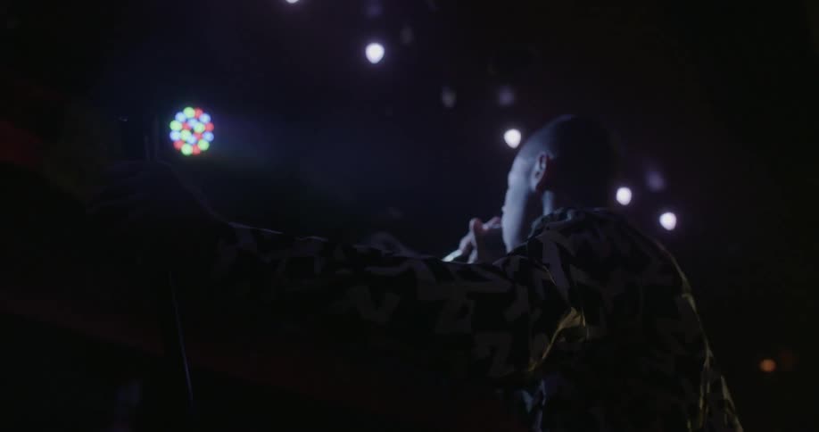 Singer performing in a dark setting