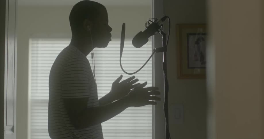Man moving rhythmically to his singing into a microphone