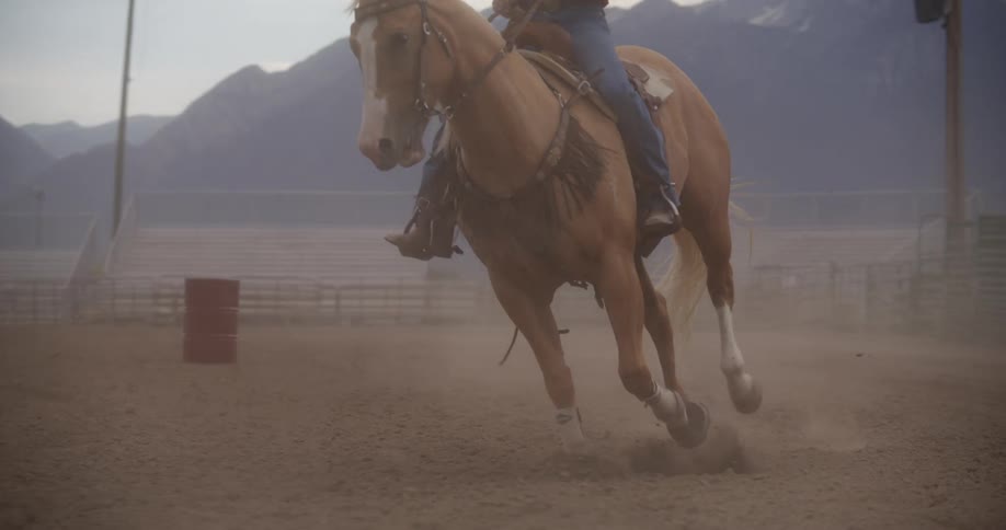 A woman riding a horse on an empty racetrack