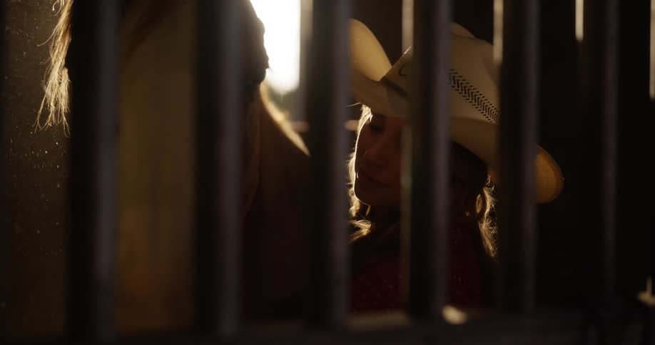 Cowgirl cleaning her horse inside a ranch