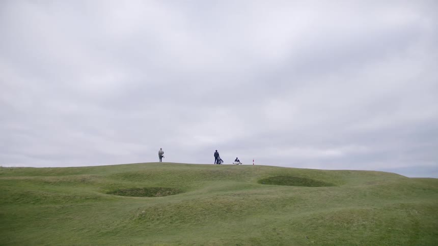 A group of people walking on a golf course