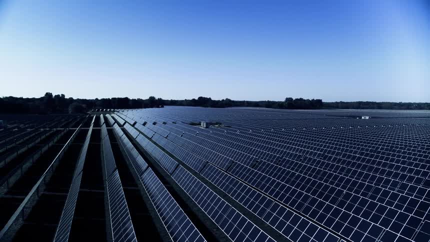 Rows of solar panels on solar farm in the middle of the day harvesting sunlight