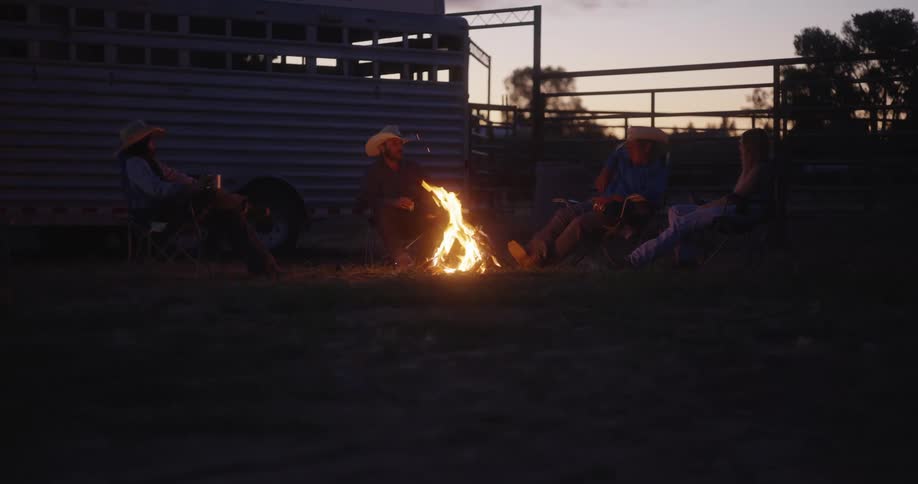 A group of people with cowboy hat around a fireplace