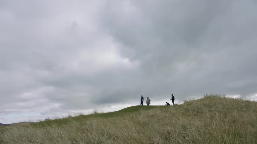 People playing golf on a hill