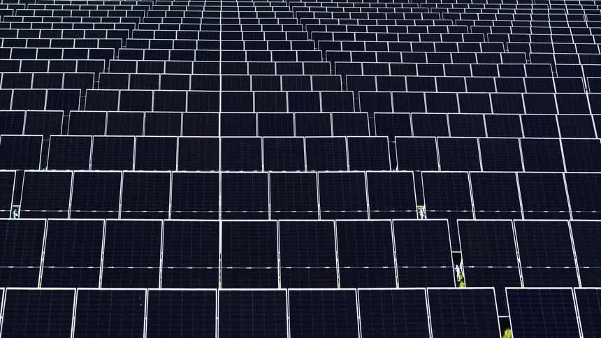 Slow moving aerial shot over rows of solar panels