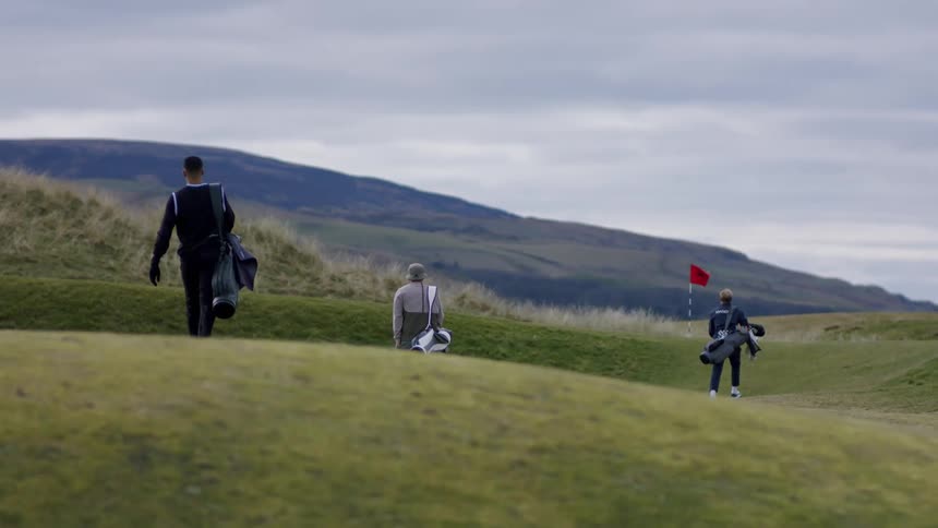 Players walking on a golf course at daytime